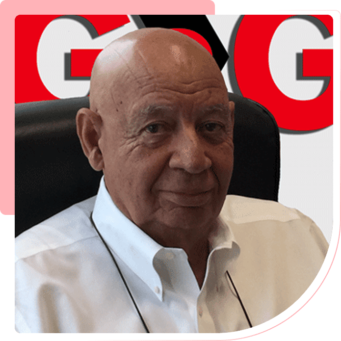 Group 1321317456 A man with an old bald head sitting in front of a red background.