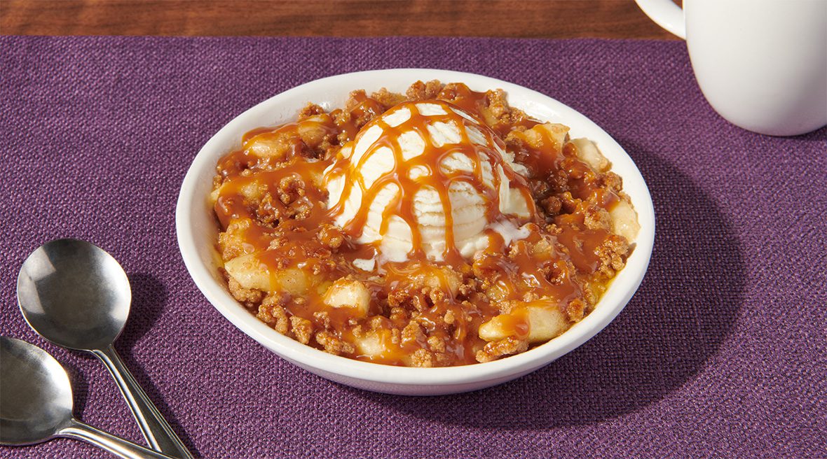 A bowl of food with ice cream and sauce.